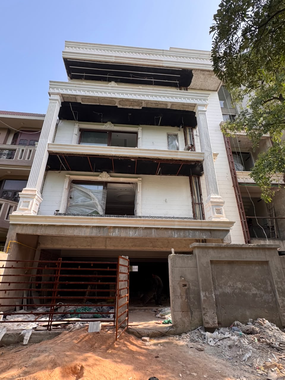 Cream stone cladding and fluted pilasters on the completed facade of our Sector 41F Noida kothi